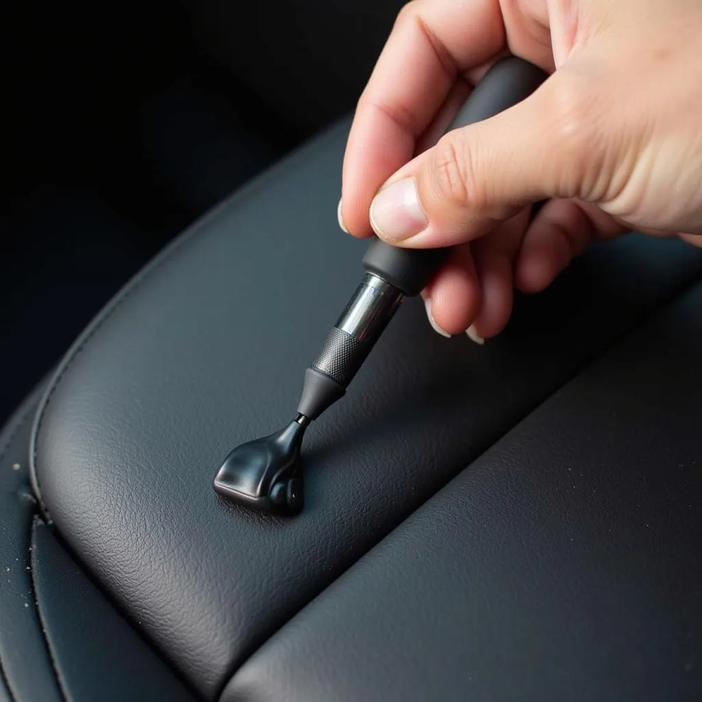 Applying black leather repair cream to a car seat