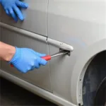 Applying Body Filler to Car Bumper