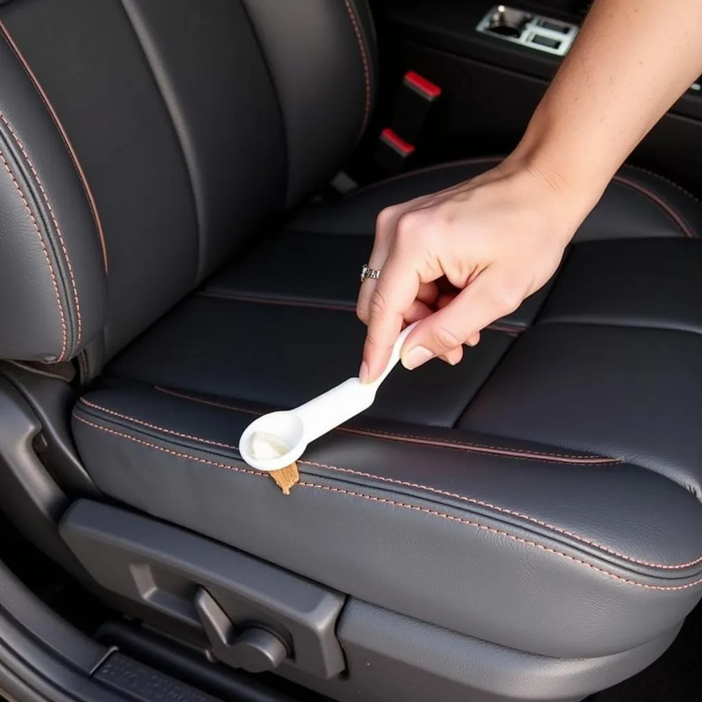 Applying leather filler to a car seat tear