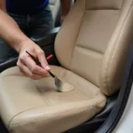 Applying leather filler to a car seat crack