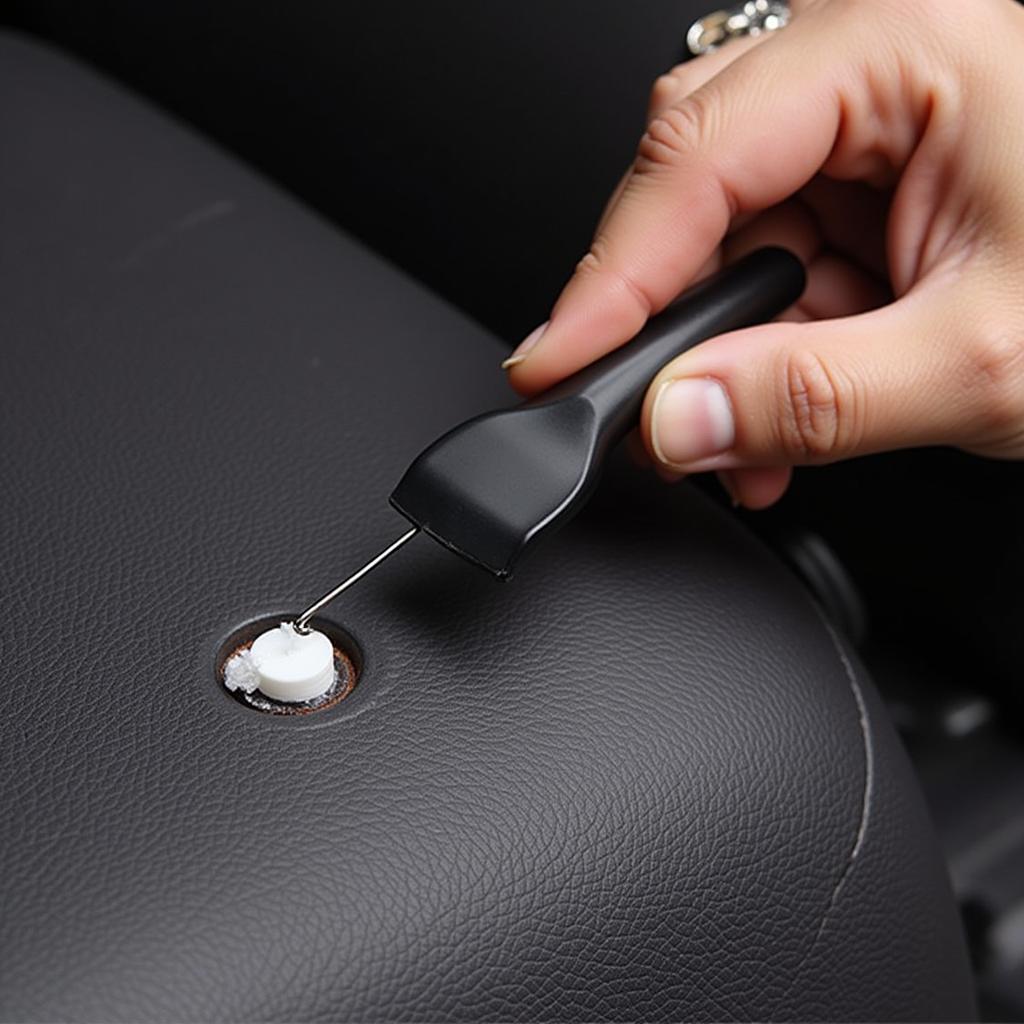 Applying leather filler to a small puncture in a car seat.