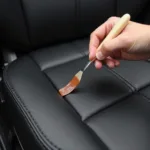 Applying liquid leather vinyl repair compound to a tear in a car seat