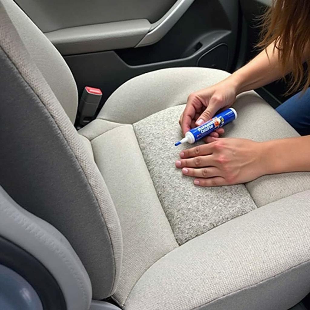 Applying a patch to a cloth car seat tear using fabric glue