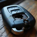 Broken Car Key Fob in Delhi - A close-up image of a damaged car key fob with cracks and a missing button, typical of the damage seen in Delhi car key repair shops.