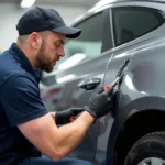 Car body repair professional assessing a dent in Billingham