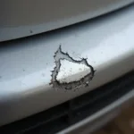 Close-up of a paint chip on a car bumper