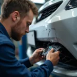 Mechanic inspecting car damage for repair in Birmingham