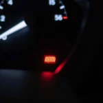 Car dashboard with illuminated airbag warning light