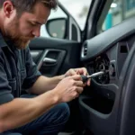 Car mechanic working on a car door to access power window mechanism