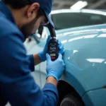 Car paint repair expert using a spectrophotometer for precise color matching in Abu Dhabi