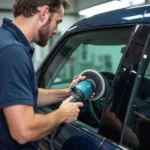 A professional technician repairing a car window scratch.