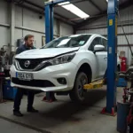 Car body shop in Chichester with a damaged car on a lift