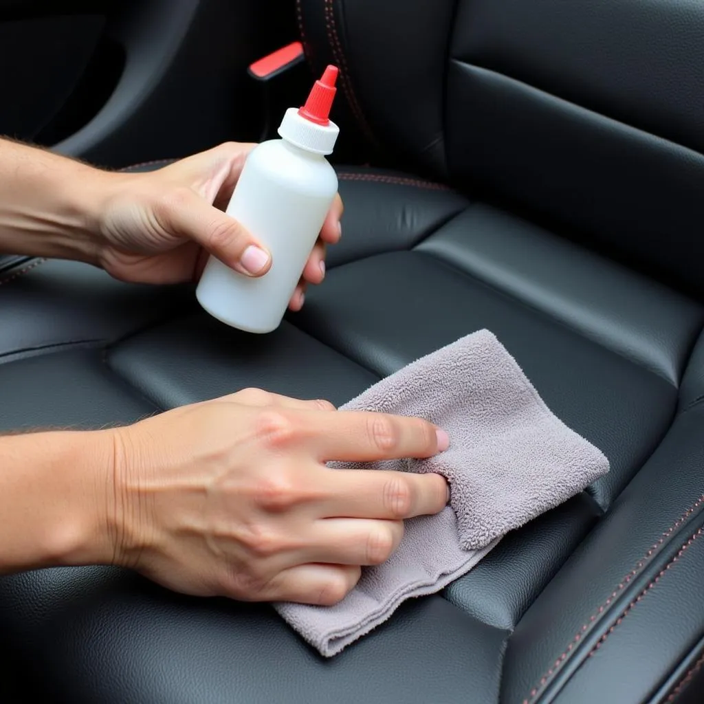 Cleaning a leather car seat tear with alcohol