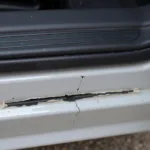 A close-up image of a damaged car door seal