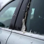 A close-up of a damaged car window trim seal