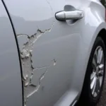 Close up view of keyed car damage, showing deep scratches in the paintwork