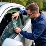 Mobile car window repair technician in Fulton County replacing a shattered side window.