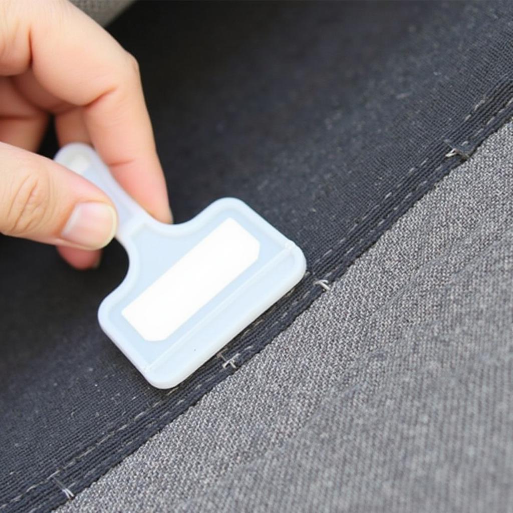 Repairing a tear in a fabric car seat with adhesive