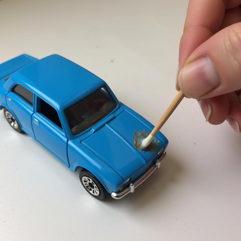 Applying paint to a chipped area on a Matchbox car with a toothpick