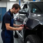 A mechanic assessing car body damage in a Bacup repair shop