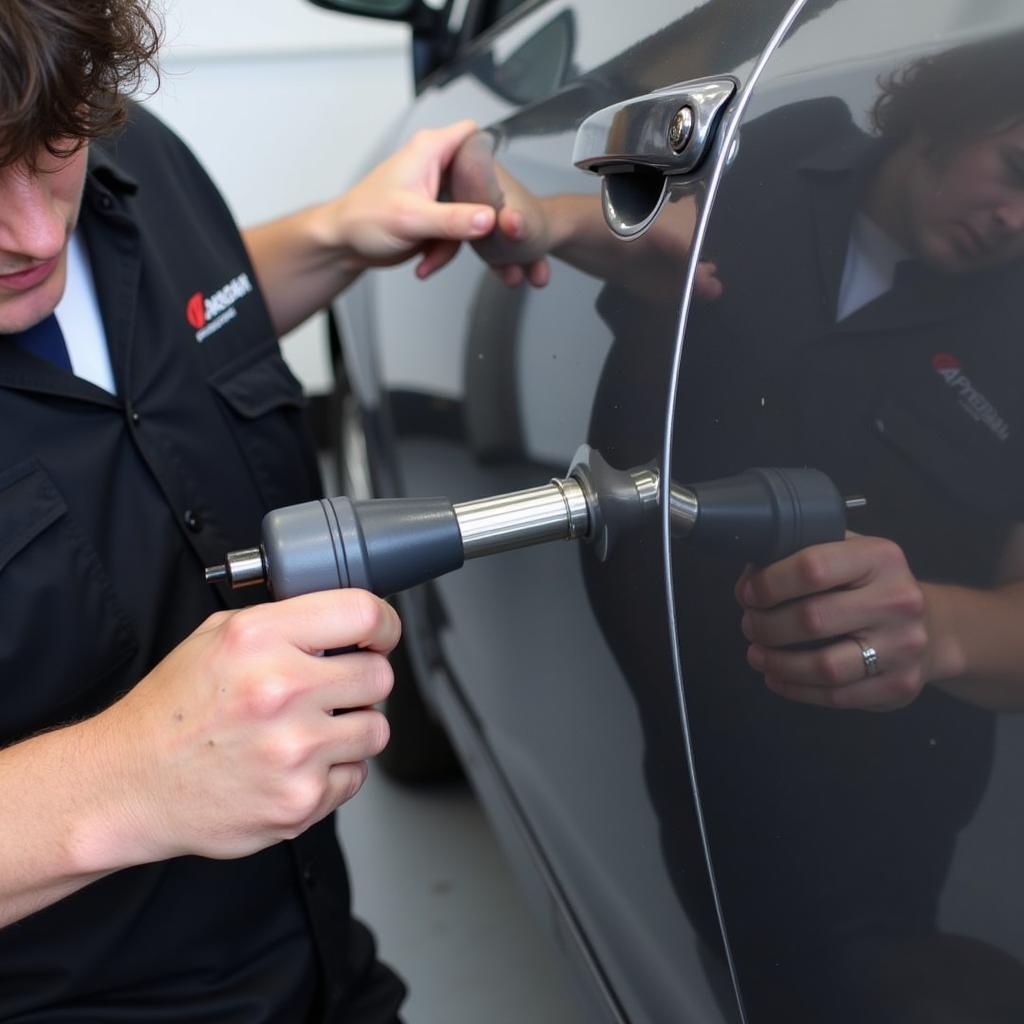 Technician performing paintless dent removal on a car in Bromsgrove.