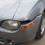 Close-up of car body damage in Hertford showing rust and dents.