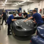 Students working on car body repair in a Redditch workshop