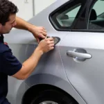 Car body repair in Farnborough: Dent removal process on a silver sedan