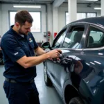 Car body repair shop in London's South East with a technician examining a damaged vehicle