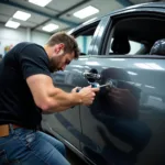 Dent removal process on a car at a Park Royal body shop