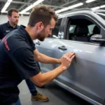 Student practicing dent removal techniques in an evening course