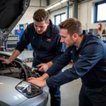 Apprentice working alongside a senior technician in a Fareham car body repair workshop