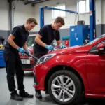 Students practicing car body repair techniques in a modern workshop