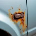 Close-up of rust forming around a car paint chip