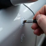 Applying touch up paint to a car scratch