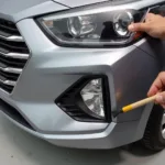 Repairing deep scratches on a Hyundai bumper using touch-up paint.