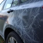 Close-up view of keyed car damage showing deep scratches