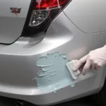 Applying UPOL Fibreglass Filler to a Damaged Car Bumper